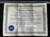 A vintage G&L Musical Products, Inc. Certificate of Authenticity document with ornate border detailing, printed text, and a blue G&L seal at the bottom left, photographed against a dark background.