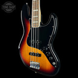 Electric bass guitar with a sunburst finish on a black background, featuring the Tone Shop logo.