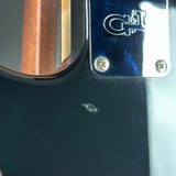 Close-up detail of a glossy black guitar body with a chrome hardware plate featuring an engraved C&H logo.