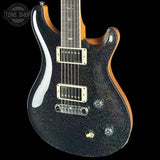 Electric guitar with a black glitter finish on a black background, featuring the Tone Shop logo.