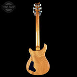 Back view of a wooden electric guitar with a black pickguard on a white background.