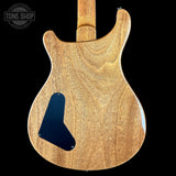 Back view of a wooden electric guitar with a black pickguard on a black background, featuring 'Tone Shop' logo.