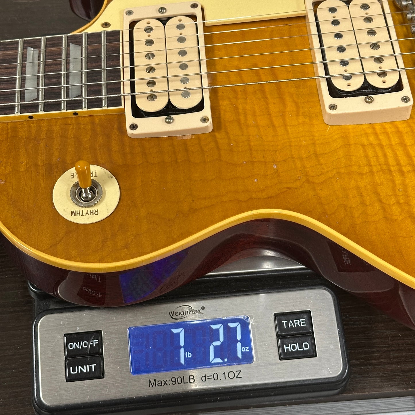 Electric guitar on a digital scale displaying weight