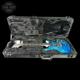 Blue electric guitar in a black case with 'Tone Shop' logo.