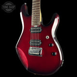 A red electric guitar with a glossy cherry finish, featuring black hardware, a maple neck, and chrome bridge, shown against a solid black background with a Tone Shop watermark in the top-left corner.