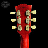 Close-up of a red guitar headstock with tuning pegs on a black background, featuring 'Tone Shop' branding.