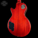 Red electric guitar with a visible brand logo on a black background