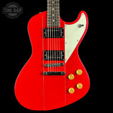 Red electric guitar with gold hardware on a black background, featuring 'Tone Shop' logo.