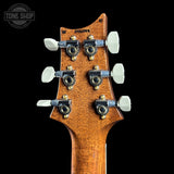 Close-up of a guitar headstock with tuning pegs on a black background, featuring 'Tone Shop' branding.
