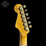 Close-up of a guitar headstock with tuning pegs on a black background, featuring the Tone Shop logo.