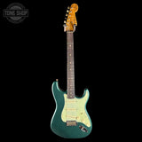 Green electric guitar with a black background