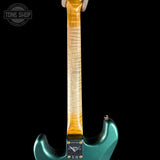 Close-up of a teal electric guitar's neck and headstock on a black background with 'Tone Shop' logo.
