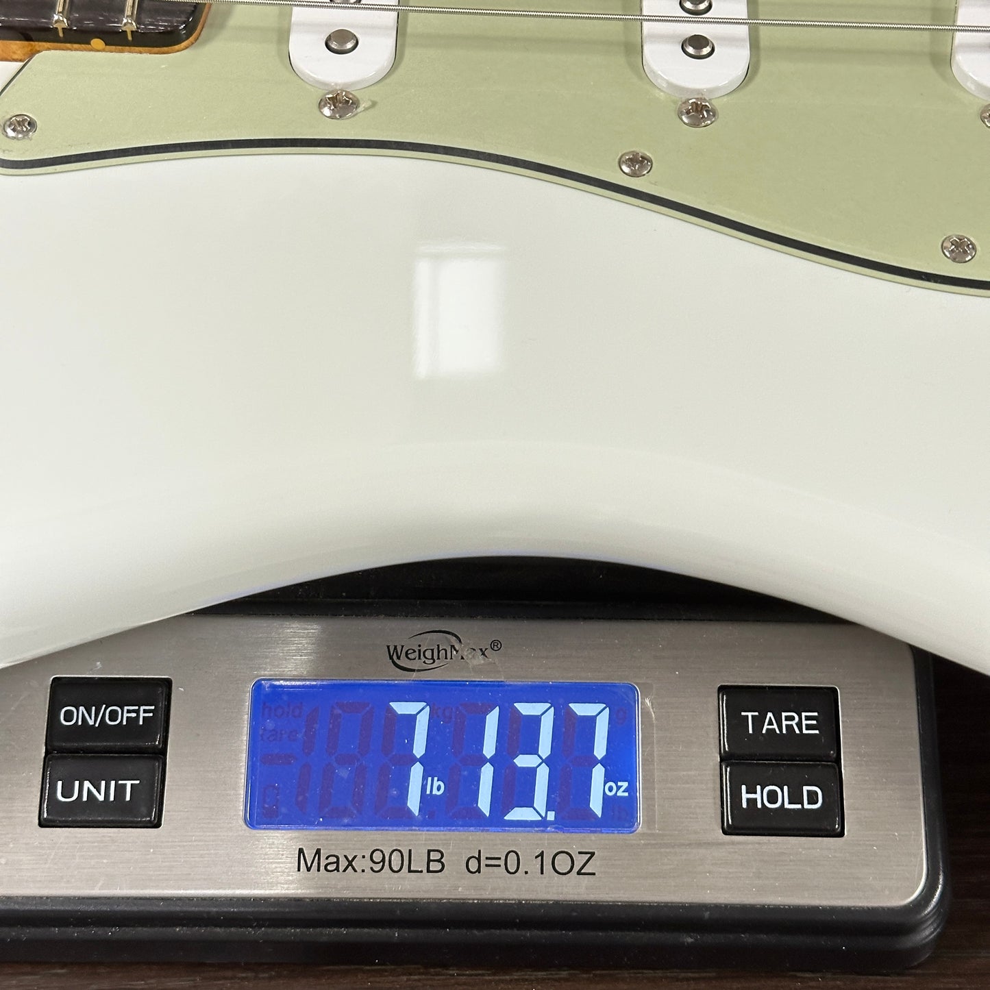 Guitar on a digital scale displaying weight