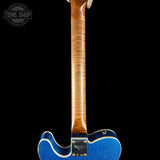 Close-up of a guitar's neck and body with a blue finish on a black background.