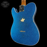 Blue electric guitar body with a 'Tone Shop' logo in the corner.