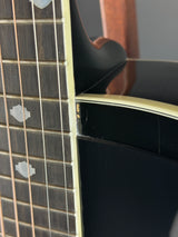 Close-up of a guitar's neck and headstock with a blurred background