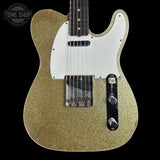 Gold glitter electric guitar with a white pickguard on a black background, featuring 'Tone Shop' branding.