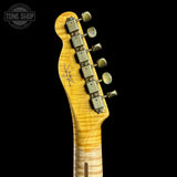 Close-up of a guitar headstock with tuning pegs on a black background, featuring the Tone Shop logo.