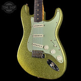 Green glitter electric guitar with a black background