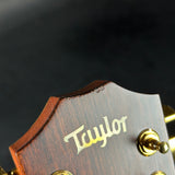 Close-up of a Taylor guitar headstock with a dark background