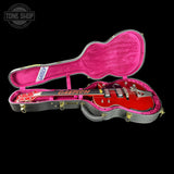 Red Gretsch guitar in a pink case with 'Tone Shop' logo.