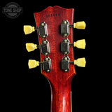Close-up of a red guitar headstock with yellow tuning pegs on a black background, featuring 'Tone Shop' branding.