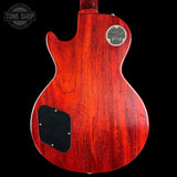 Red electric guitar body with a visible brand logo on a black background
