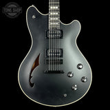 Silver electric guitar on a black background with 'Tone Shop' logo.