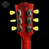 Close-up of a red guitar headstock with tuning pegs on a black background, featuring 'Tone Shop' branding.