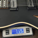 Guitar on a digital scale displaying weight