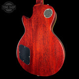 Red electric guitar body with a visible brand logo on a black background