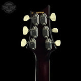Close-up of the headstock of an electric guitar against a black background, showing six cream-colored tuning pegs and a yellow model number '52076261' printed on the back. A Tone Shop watermark is visible in the top left corner.