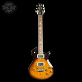 A classic electric guitar with a sunburst finish, shown vertically against a solid black background. The brand 'Gibson' is clearly visible on the headstock.