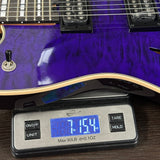 Purple electric guitar on a digital scale displaying weight
