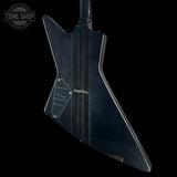 The rear view of an electric guitar with a distinctive angular body, finished in a dark, glossy black or very deep navy color. The backplate features a pickguard, control knobs, and a small gold 'Gibson' logo near the center.