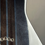 Close-up of an electric guitar body showing dark wood stripes, a glossy white edge, and four metal hardware eyelets on a light gray background.