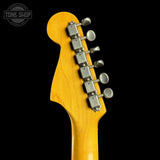 Close-up of a guitar headstock with tuning pegs on a black background, featuring the Tone Shop logo.