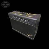 A black Magnatone guitar amplifier with gold trim and gold knobs, shown at a three-quarter angle against a solid black background.