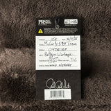 A black and white product tag for aPRS Strings vintage 10-gauge steel string guitar string set, placed on a dark brown textured faux fur background.