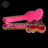 Guitar in a pink case with a visible 'Tone Shop' logo.