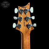 Close-up of the headstock of a wooden electric guitar, showing six tuning pegs, tuning screws, and the brand name 'WOOD LEAF' printed vertically on the back of the headstock. The headstock is made of warm brown wood with black and gold hardware, set against a solid black background.