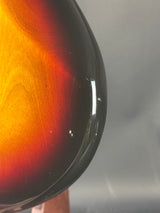 Close-up of a guitar's soundhole with a gradient from red to black.