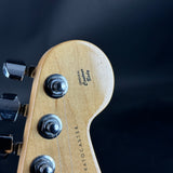 Close-up of a guitar headstock with 'Fender' branding on a dark background