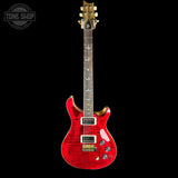 A red electric guitar with a flamed maple top, gold hardware, and a dark fretboard, shown against a solid black background with a Tone Shop watermark in the top left corner.