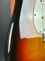 Close-up of a guitar's neck and headstock with a sunburst finish.