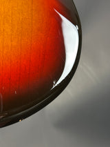 Close-up of a guitar's wooden fretboard with a gradient of colors.
