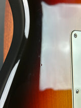 Close-up of a guitar's neck and headstock with a visible brand logo.