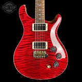 A red electric guitar with a flamed maple top and a dark wood neck, photographed against a solid black background. A Tone Shop watermark is visible in the top left corner.