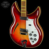 Electric guitar with a red and white body on a black background, featuring the Tone Shop logo.