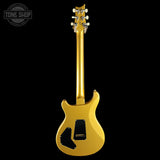 A gold electric guitar shown from the back against a solid black background, with a Tone Shop watermark in the top-left corner.